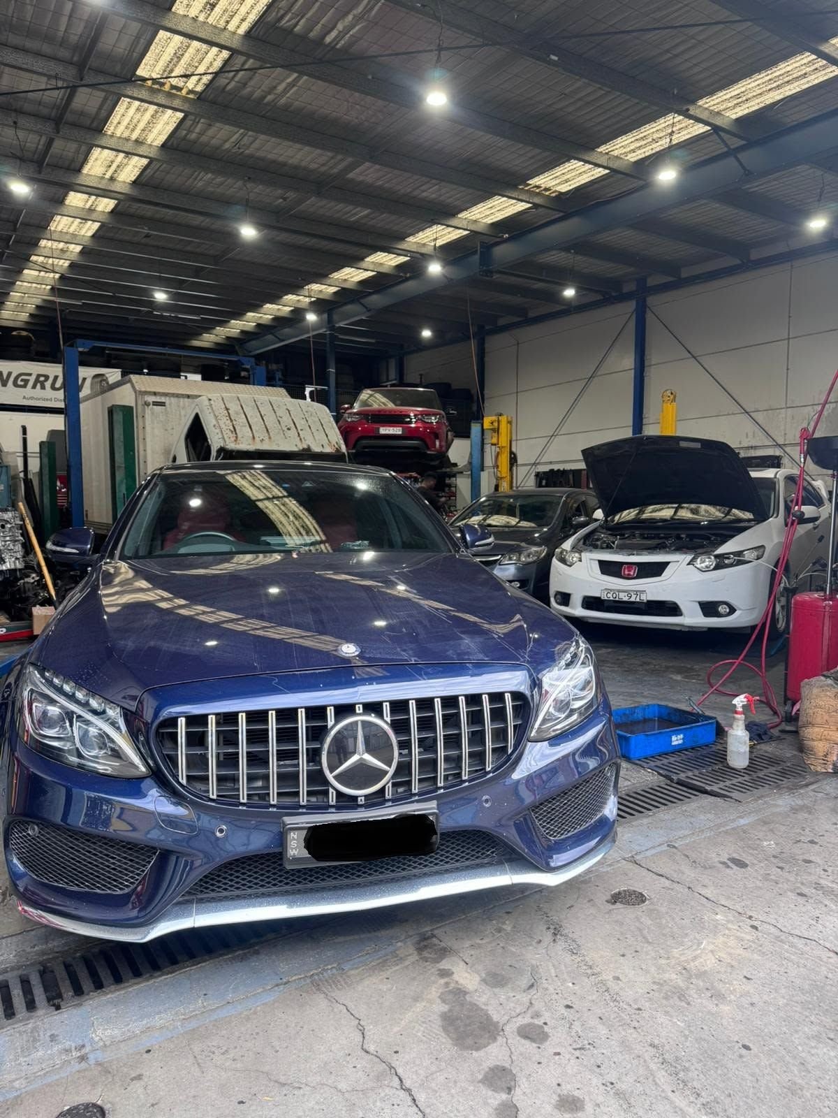 Blue Mercedes-Benz C-Class in a service bay